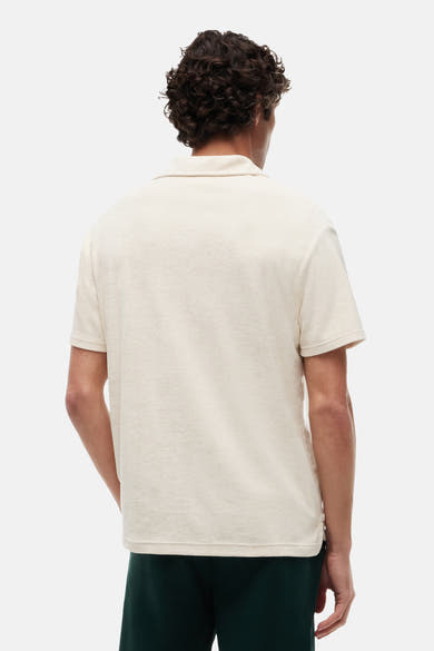 Polo écru de TOMMY HILFIGER à texture éponge, vue arrière, porté avec un short vert foncé.