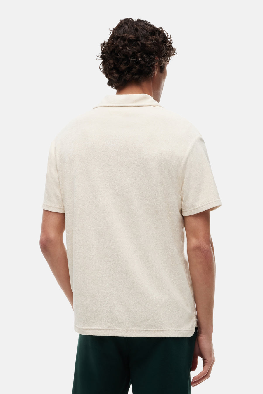 Polo écru de TOMMY HILFIGER à texture éponge, vue arrière, porté avec un short vert foncé.