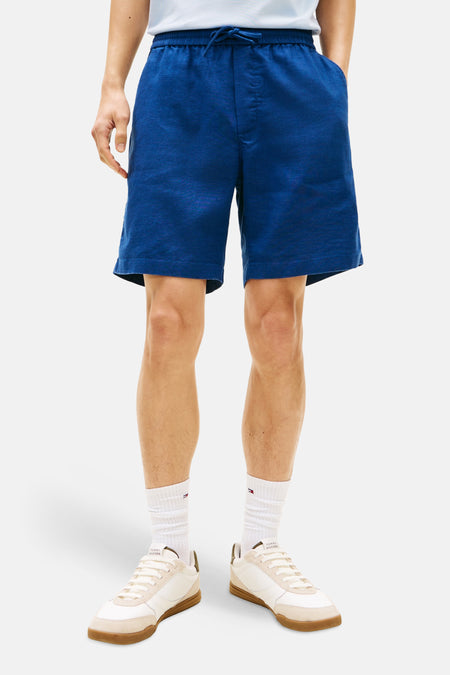 Blauwe bermuda van Tommy Hilfiger, met trekkoord en voorzakken, gedragen met een lichtblauw poloshirt.