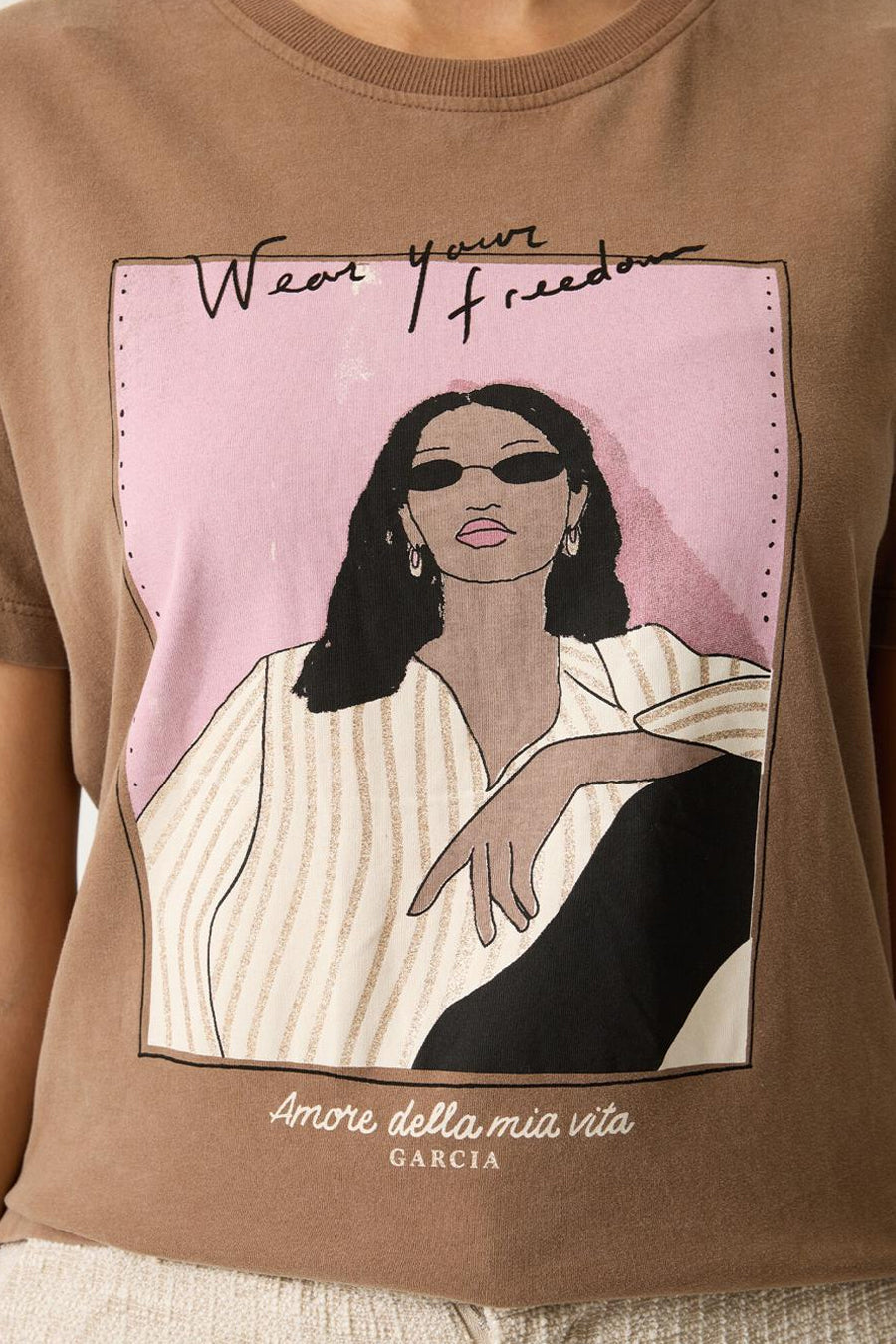 T-shirt taupe à manches courtes de Garcia, avec motif imprimé d'une femme stylisée sur fond rose.