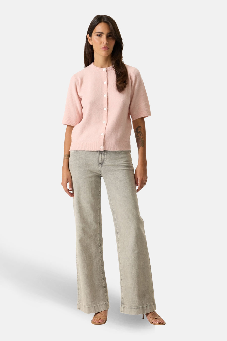 Cardigan rose de GARCIA avec manches courtes porté avec un jean taille haute et des sandales.