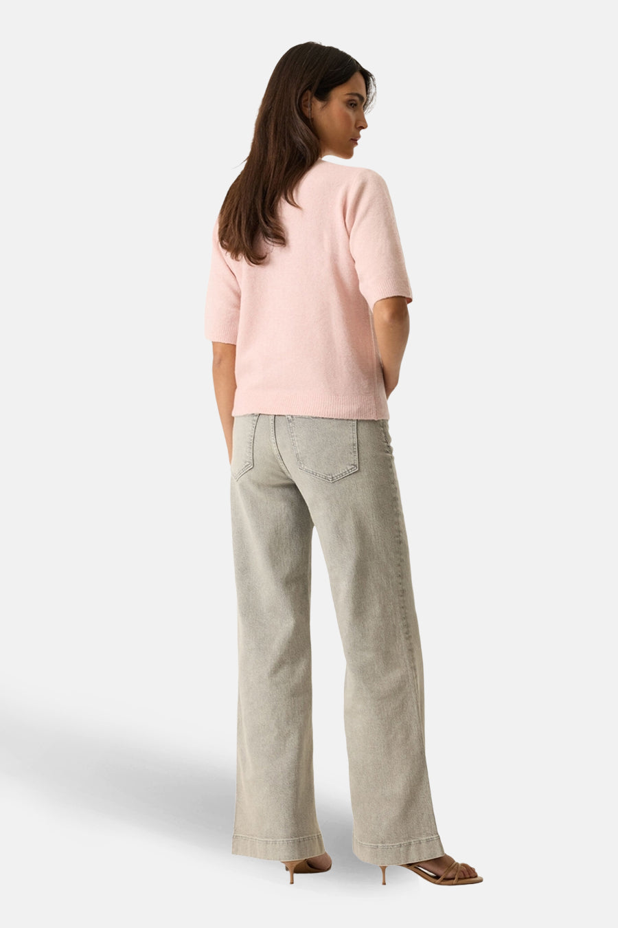 Cardigan rose de GARCIA, porté avec un jean gris taille haute et des sandales à talons, vue de dos.
