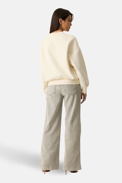 Ecru sweatshirt van GARCIA, relaxte pasvorm, gedragen met een wijde grijze jeans en bruine hakken.