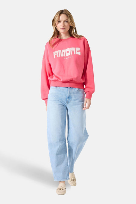 Sweat rose GARCIA, porté avec un jean ample bleu clair et des mocassins beiges.