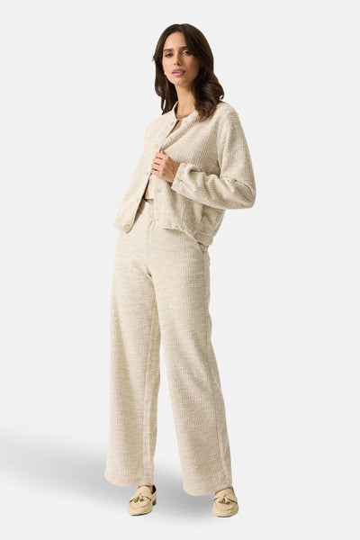Korte beige jas van GARCIA, getextureerd, gedragen met een bijpassende broek en lichte loafers.