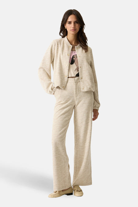 Pantalon de costume beige de GARCIA, à jambes larges, en tweed, porté avec un t-shirt imprimé et des mocassins.