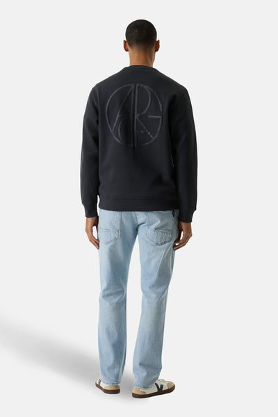 Pull gris de GARCIA, avec grand logo circulaire ton sur ton au dos, porté avec un jean bleu clair et des baskets.
