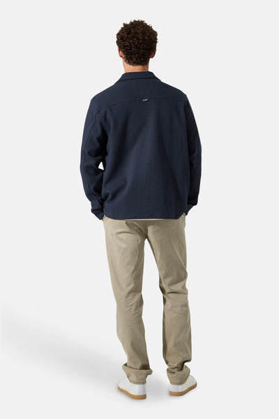 Chemise à manches longues bleue de GARCIA, vue de dos, avec pantalon beige et chaussures blanches.