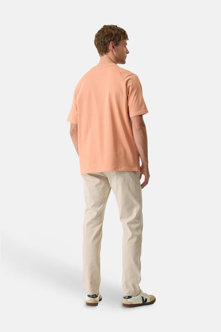 Pantalon chino écru de GARCIA, porté avec un t-shirt orange, vue de dos.