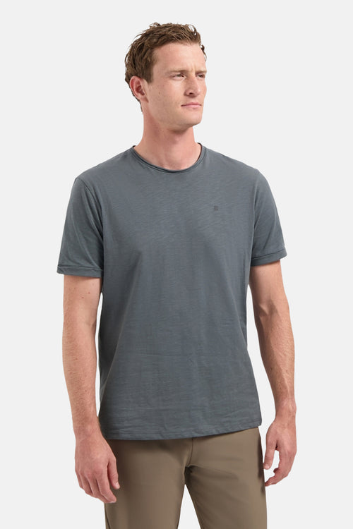 Grijs T-shirt met korte mouwen van NO EXCESS, gedragen met een kaki broek en witte sneakers met bruine zolen.