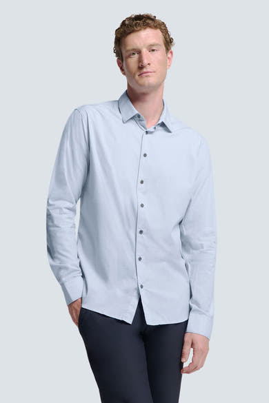 Chemise à manches longues bleue de NO EXCESS, avec une texture subtile et portée avec un pantalon foncé.
