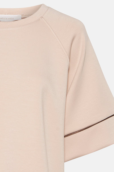 Sweat-shirt beige à col rond de AMELIE ET AMELIE, avec manches raglan et bordures marron.