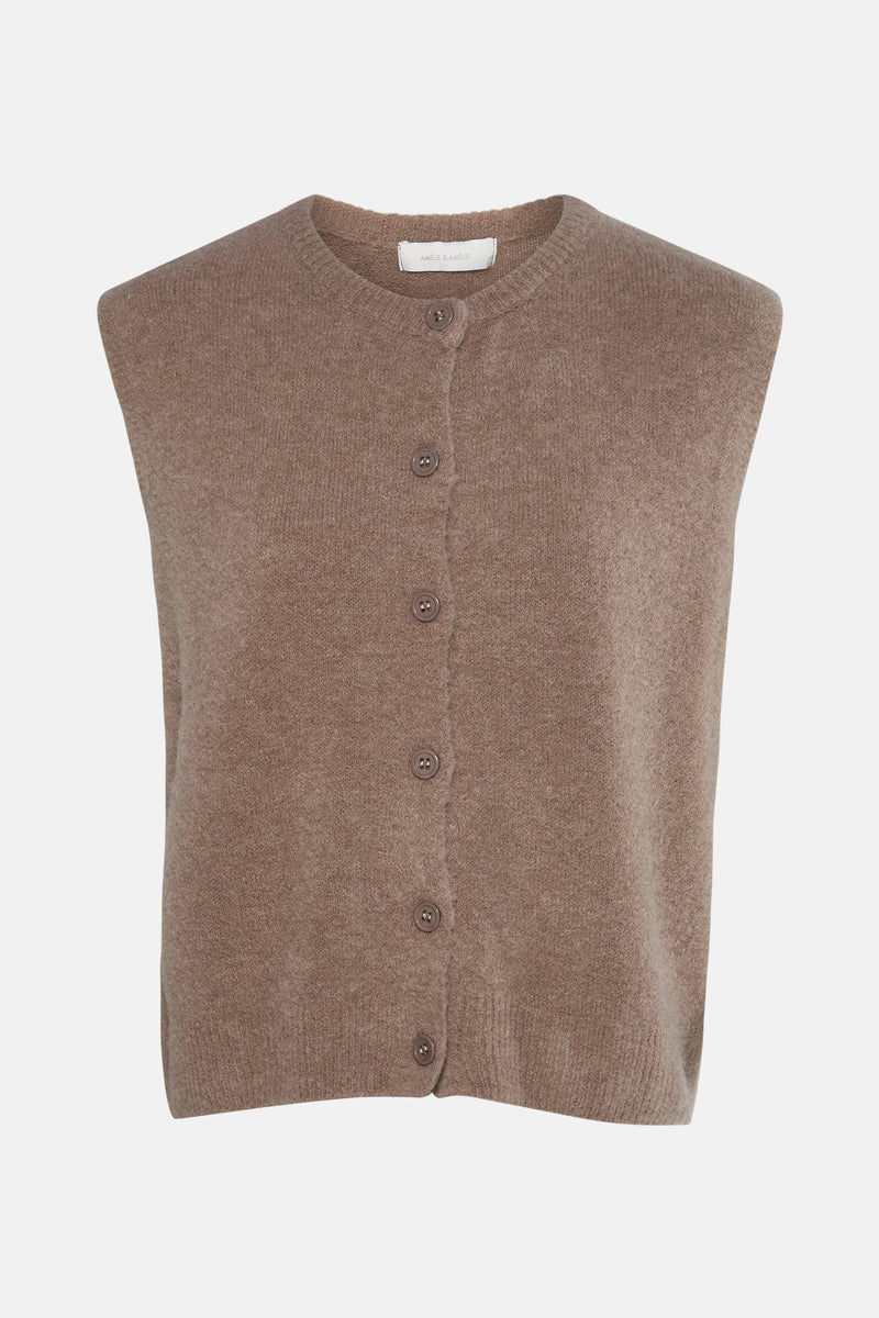 Gilet beige en tricot de AMÉLIE ET AMÉLIE, à boutons sur fond uni.
