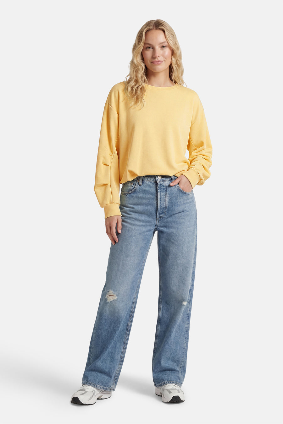 Sweat jaune de AMELIE ET AMELIE avec manches longues amples et détails structurés, porté avec un jean bleu délavé.
