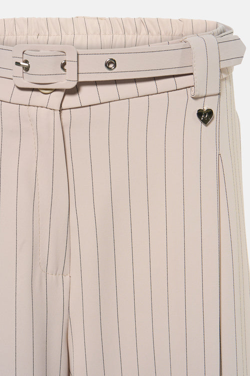 Pantalon de costume beige rayé de Amelie et Amelie, avec ceinture assortie, détail cœur décoratif.