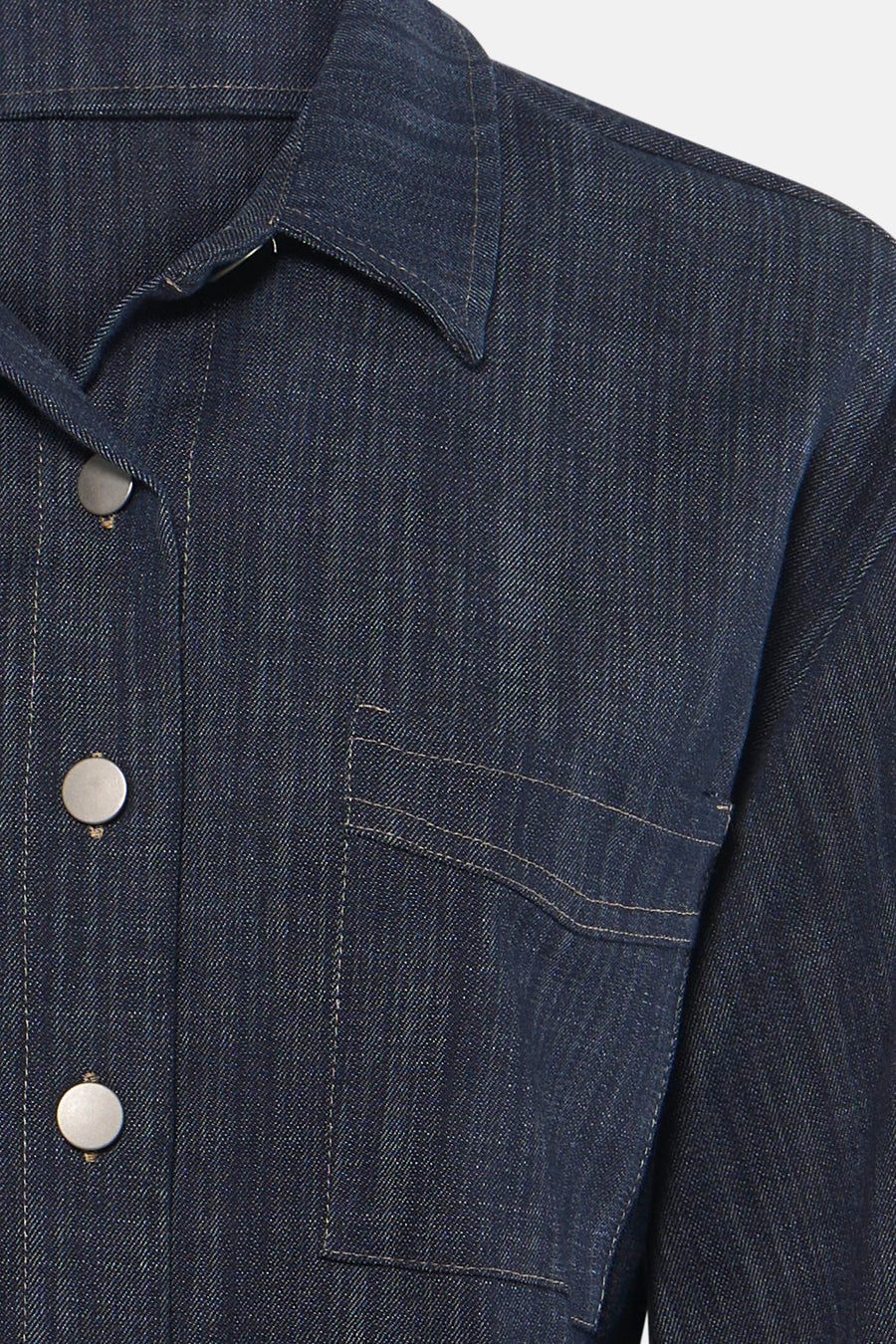 Chemise en denim bleu foncé à manches longues par AMELIE ET AMELIE, avec col classique, boutons métalliques et poche plaquée, vue rapprochée.