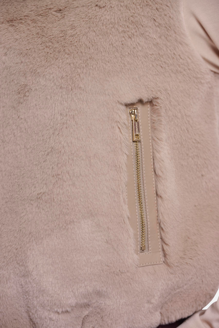 Beige faux fur bodywarmer by RINO PELLE with gold zipper and leather trim, close-up side view