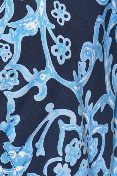 ZABAIONE blauwe jurk, met een lichtblauw gestileerd bloemenpatroon op een marineblauwe achtergrond.