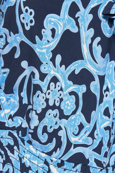 Robe bleue de ZABAIONE avec motif floral bleu et détails froncés, en gros plan.
