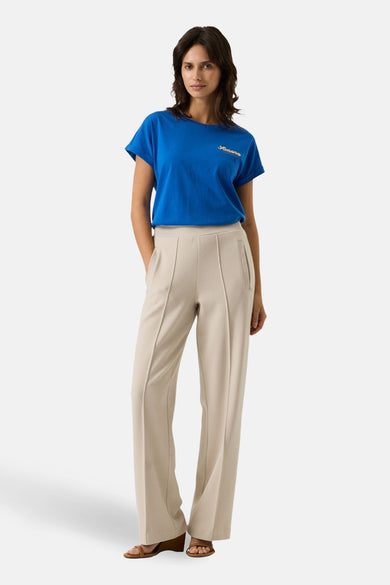 T-shirt bleu à manches courtes de GARCIA, avec inscription brodée sur la poitrine, porté avec un pantalon beige.

