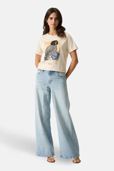 Beige T-shirt met decoratieve print van GARCIA, gedragen met een lichtblauwe wijde jeans en bruine sandalen.