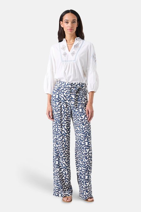 Chemisier blanc à manches longues de GARCIA, avec broderie décorative et pantalon imprimé à taille haute.
