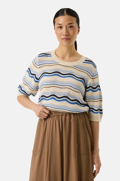 Pull multicolore de GARCIA, à rayures ondulées bleues, marron et crème, porté avec une jupe marron ample.