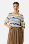 Pull multicolore de GARCIA, à rayures ondulées bleues, marron et crème, porté avec une jupe marron ample.
