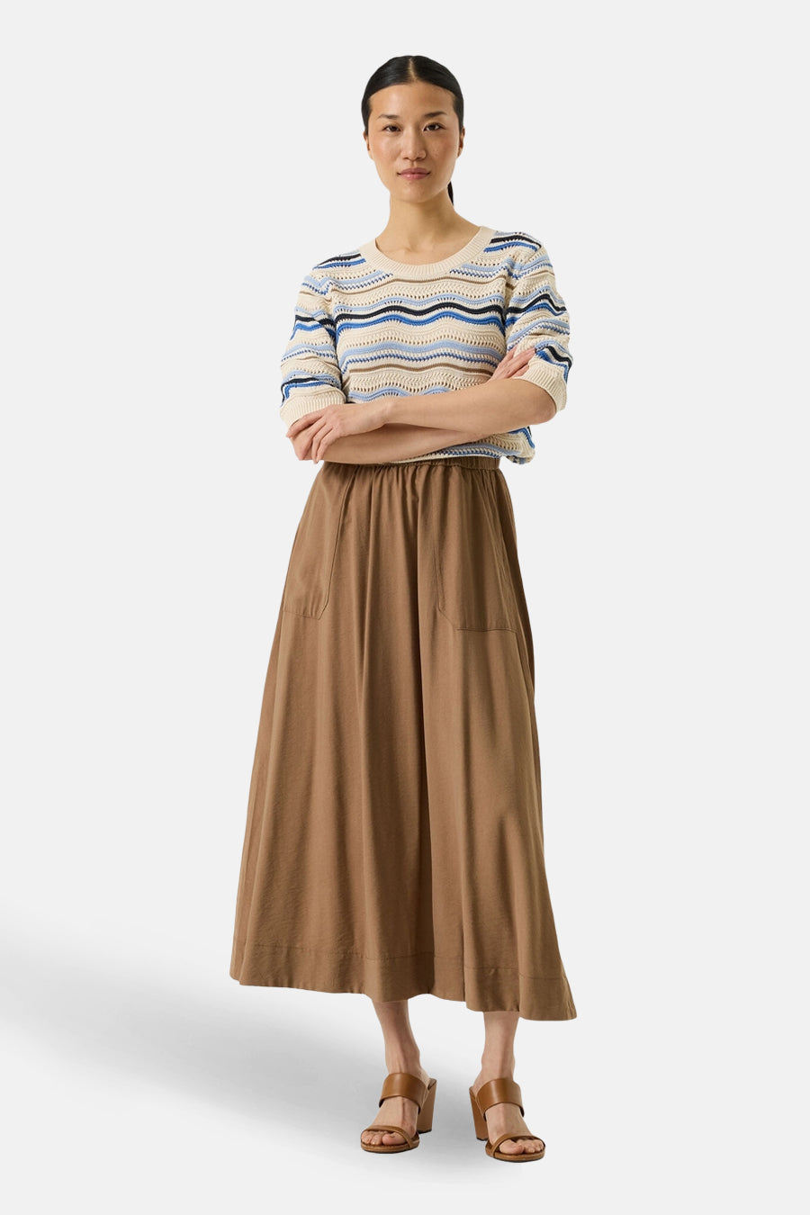 Pull multicolore de GARCIA avec rayures horizontales, porté avec une jupe marron ample et des sandales à talons.