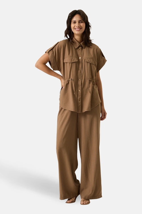 Pantalon taupe de GARCIA, avec une coupe ample et des jambes larges, porté avec des sandales à talons.
