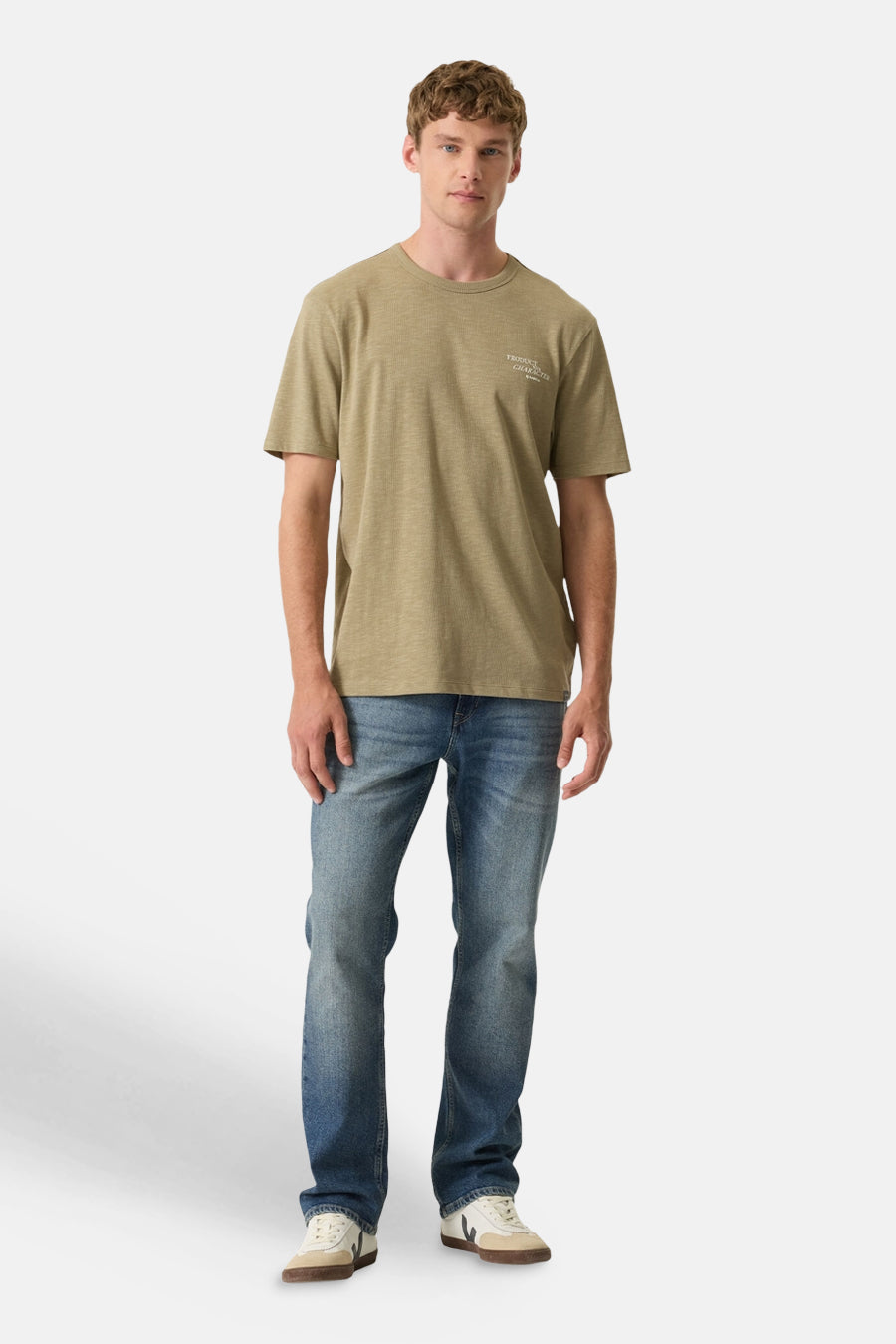 Groen T-shirt van GARCIA, met een klein logo op de borst, gedragen met een blauwe spijkerbroek en crèmekleurige sneakers.