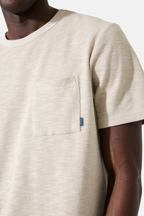 T-shirt écru de GARCIA, avec poche poitrine et petite étiquette bleue.