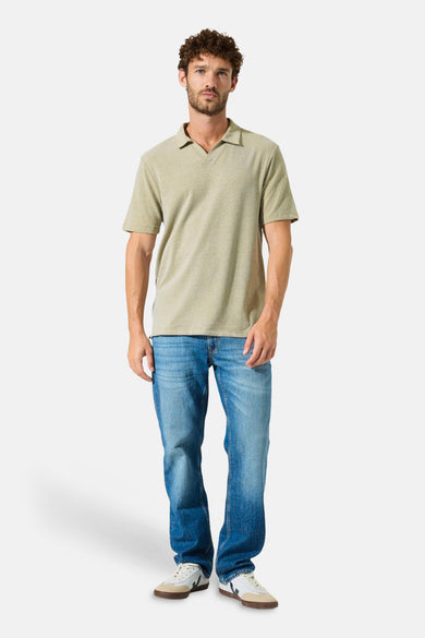 Polo vert clair de GARCIA, porté avec un jean bleu et des baskets beiges et blanches.