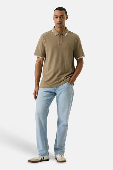 Groen poloshirt van GARCIA met witte bies op de kraag en mouwen, gedragen met een lichte spijkerbroek.