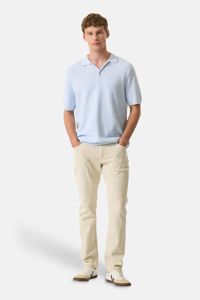 Polo blanc de GARCIA, porté avec un pantalon beige clair et des baskets décontractées.