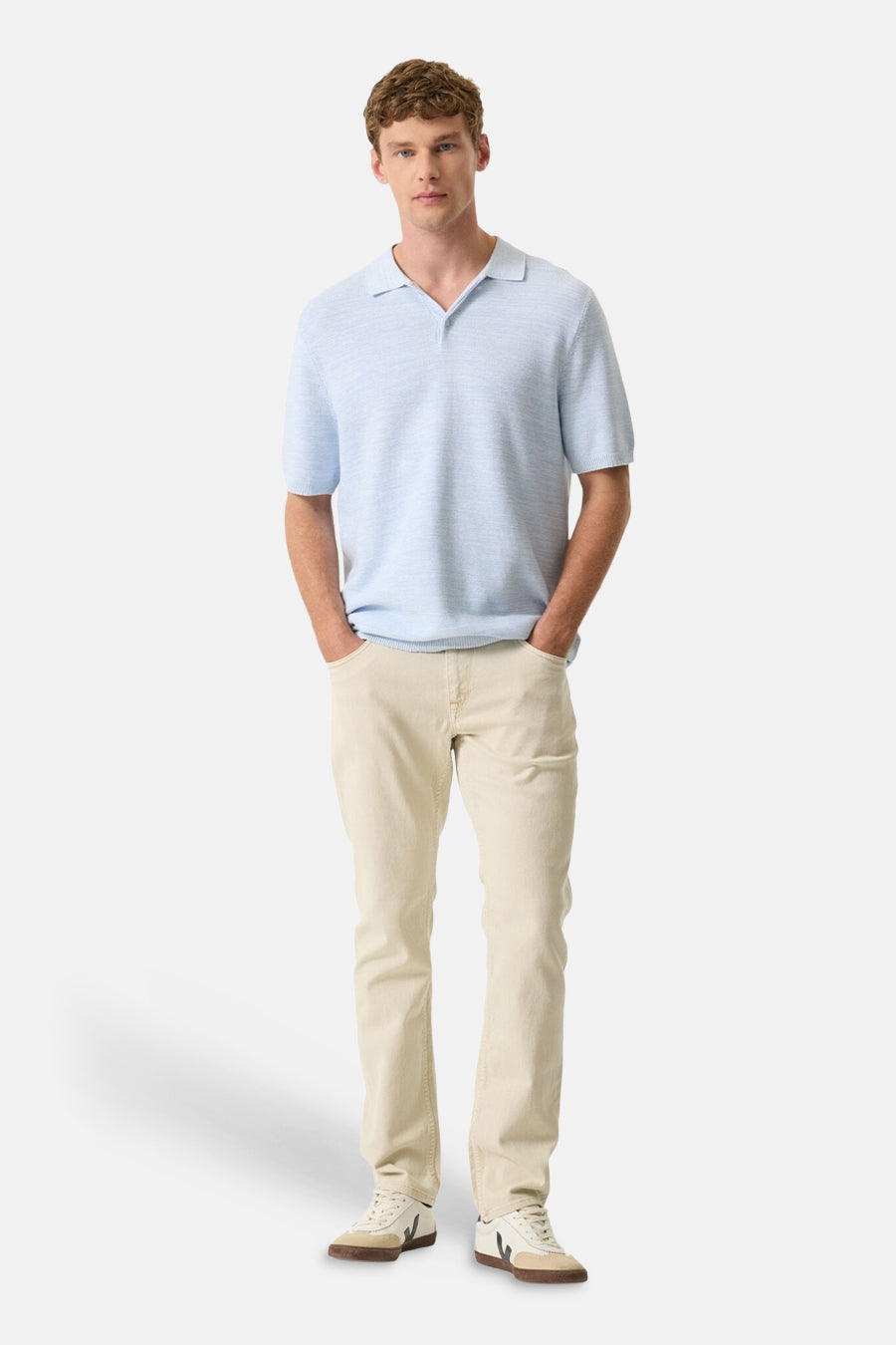 Polo blanc de GARCIA, porté avec un pantalon beige clair et des baskets décontractées.