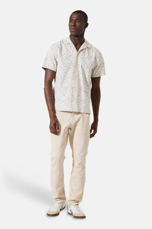 Beige overhemd met korte mouwen van GARCIA, met een subtiel geometrisch patroon, gedragen met een beige broek en witte sneakers.
