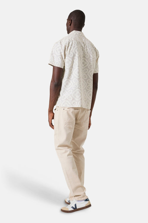 Beige overhemd met korte mouwen van GARCIA met sierpatroon en knopen, gedragen met een beige broek en sneakers.