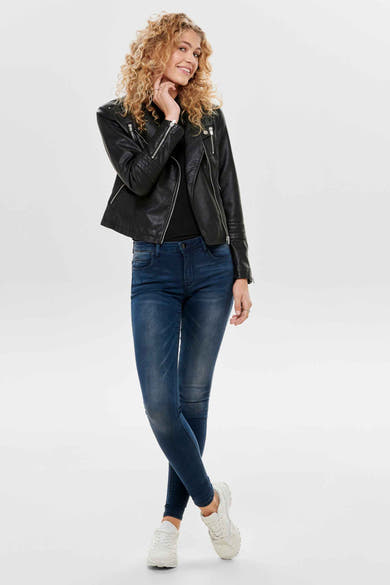 Zwarte imitatielederen jas van ONLY, gedragen met een blauwe jeans en witte sneakers.