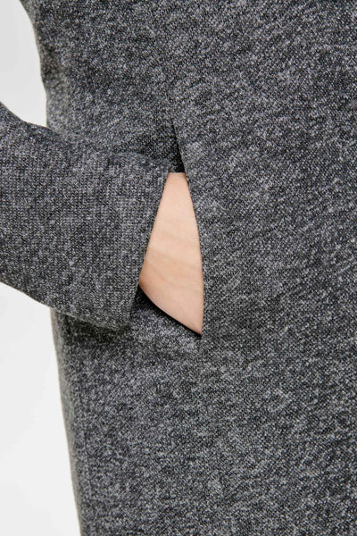 Veste longue grise de ONLY, avec une main dans la poche en tissu texturé chiné.
