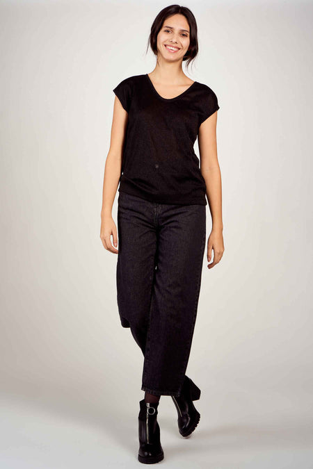 Top noir à manches courtes de ONLY, porté avec un jean large et des bottines noires.
