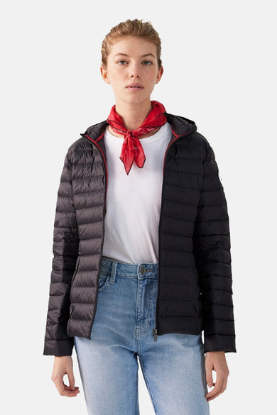 Veste de pluie noire par JOTT, portée avec un foulard rouge et un t-shirt blanc et un jean.