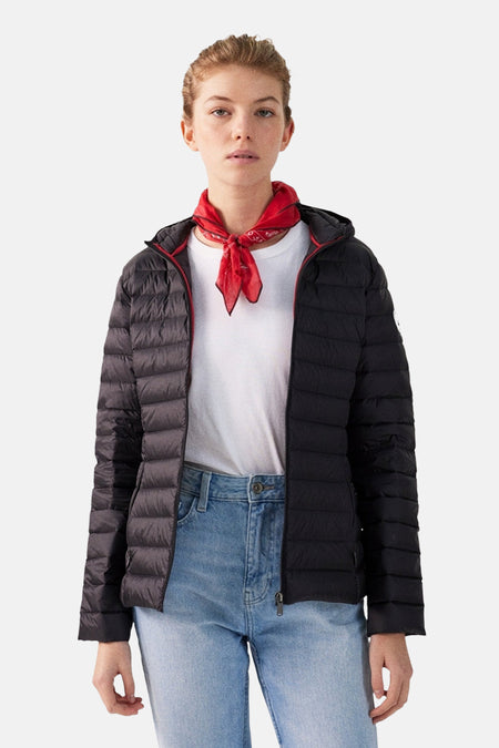 Veste de pluie noire par JOTT, portée avec un foulard rouge et un t-shirt blanc et un jean.