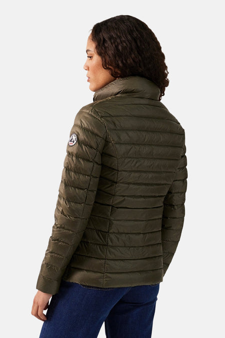 Veste de pluie kaki par JOTT, matelassée avec un col montant, portée avec un jean bleu.