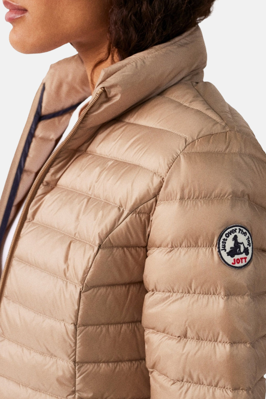 Veste de pluie beige de JOTT, matelassée avec un col montant.