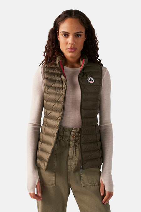 Kaki mouwloos vest van JOTT, gedragen door een vrouw met een beige trui en een bijpassende broek.