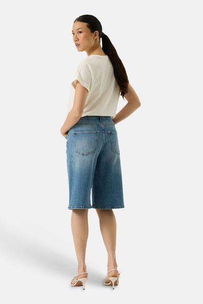 T-shirt écru à manches courtes de GARCIA, porté avec un short en jean et des sandales à talons aiguilles, vue de dos.