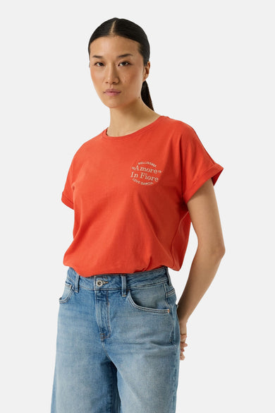 T-shirt orange à manches courtes de Garcia, avec motif imprimé sur le devant et porté avec un jean.
