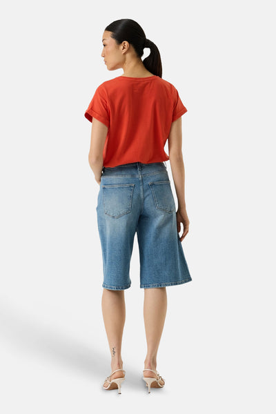 T-shirt orange de GARCIA, porté avec un pantacourt en jean et des talons hauts ivoire, vue de dos.