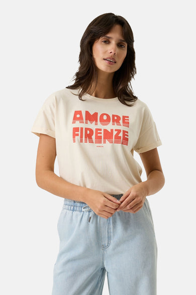 Ecru short-sleeve t-shirt with bold red "AMORE FIRENZE" graphic, worn by model in light denim pants, front view
